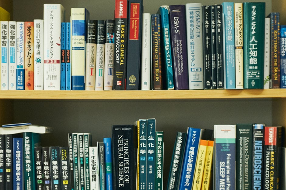 上田さんの研究室の本棚。システム生物関連の専門書が並ぶ。